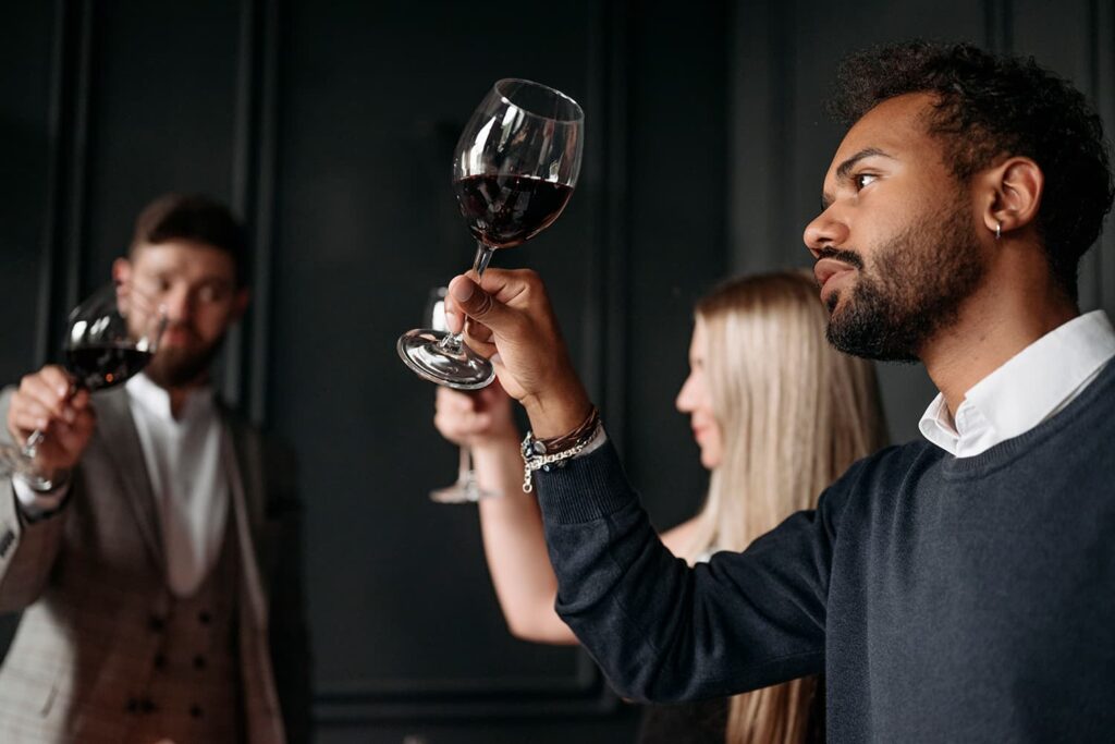 Grupo de personas observando el color del vino en una cata